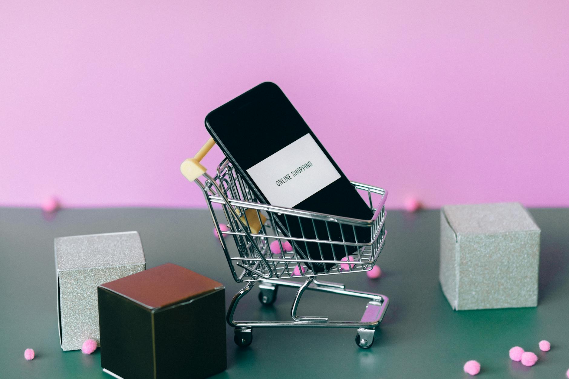 black smartphone on miniature shopping cart